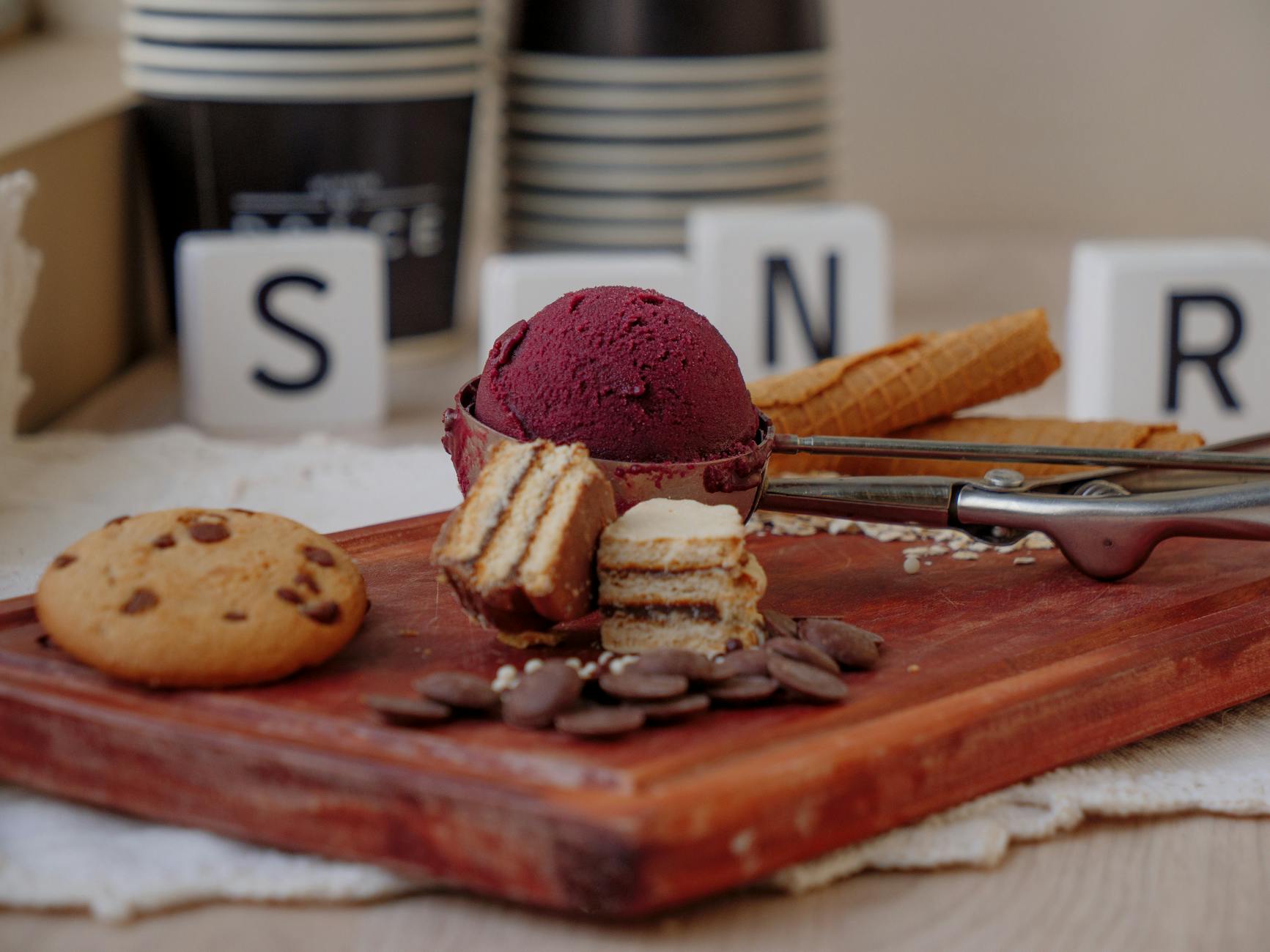 Deska z lodami, ciastkami i kolorowymi słodyczami na drewnianym stole