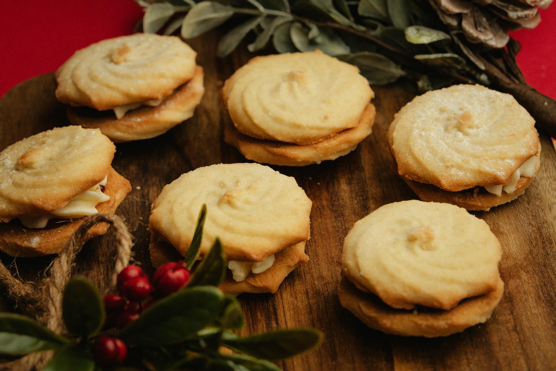 Maślane kruche ciastka z delikatnym kremowym nadzieniem na talerzu