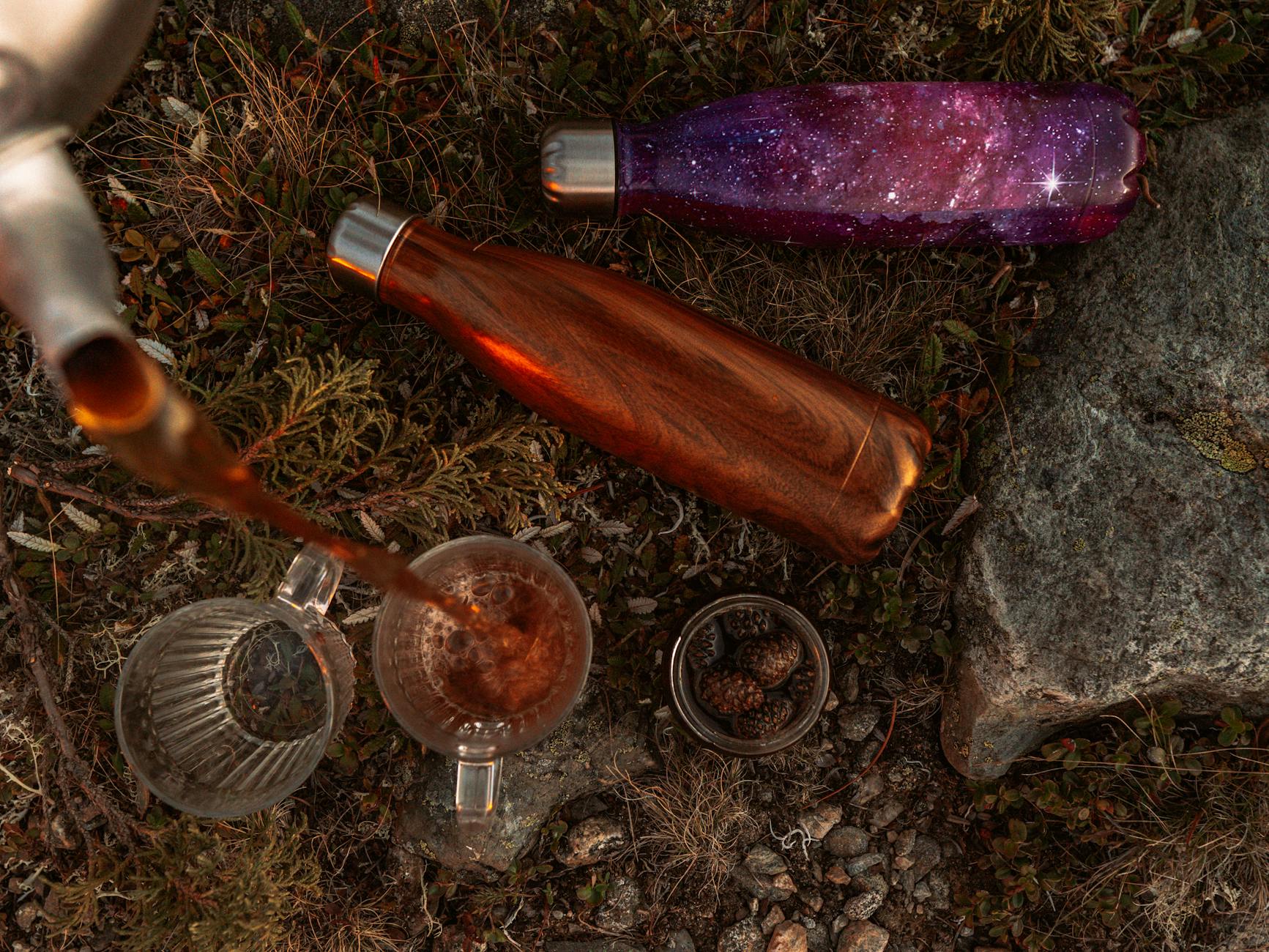 Nalewanie herbaty na zewnątrz z termosów stojących na ziemi