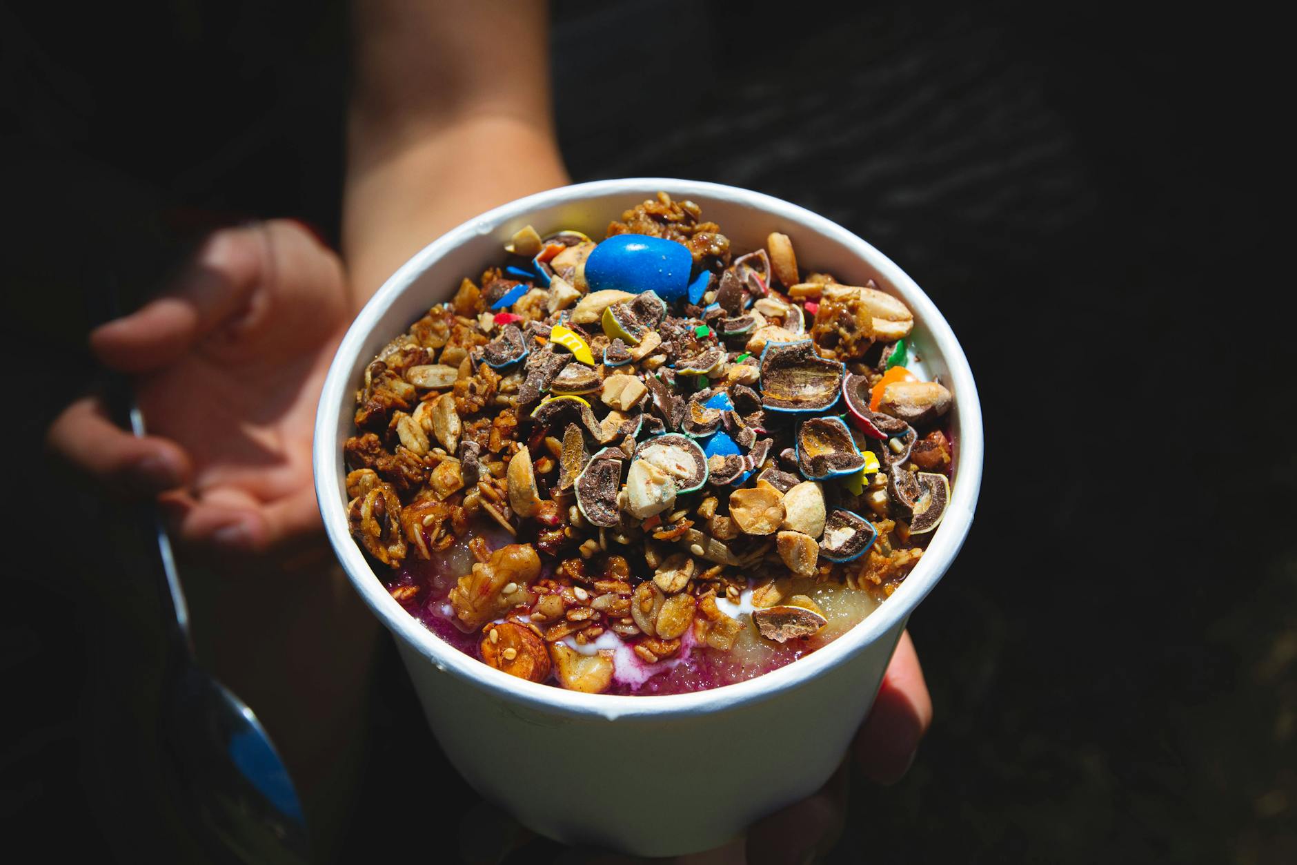 Czekolada do owsianki i jogurtu: wiórki, krople czy tabliczka? Miska smoothie z granolą i kawałkami czekolady w białej misce