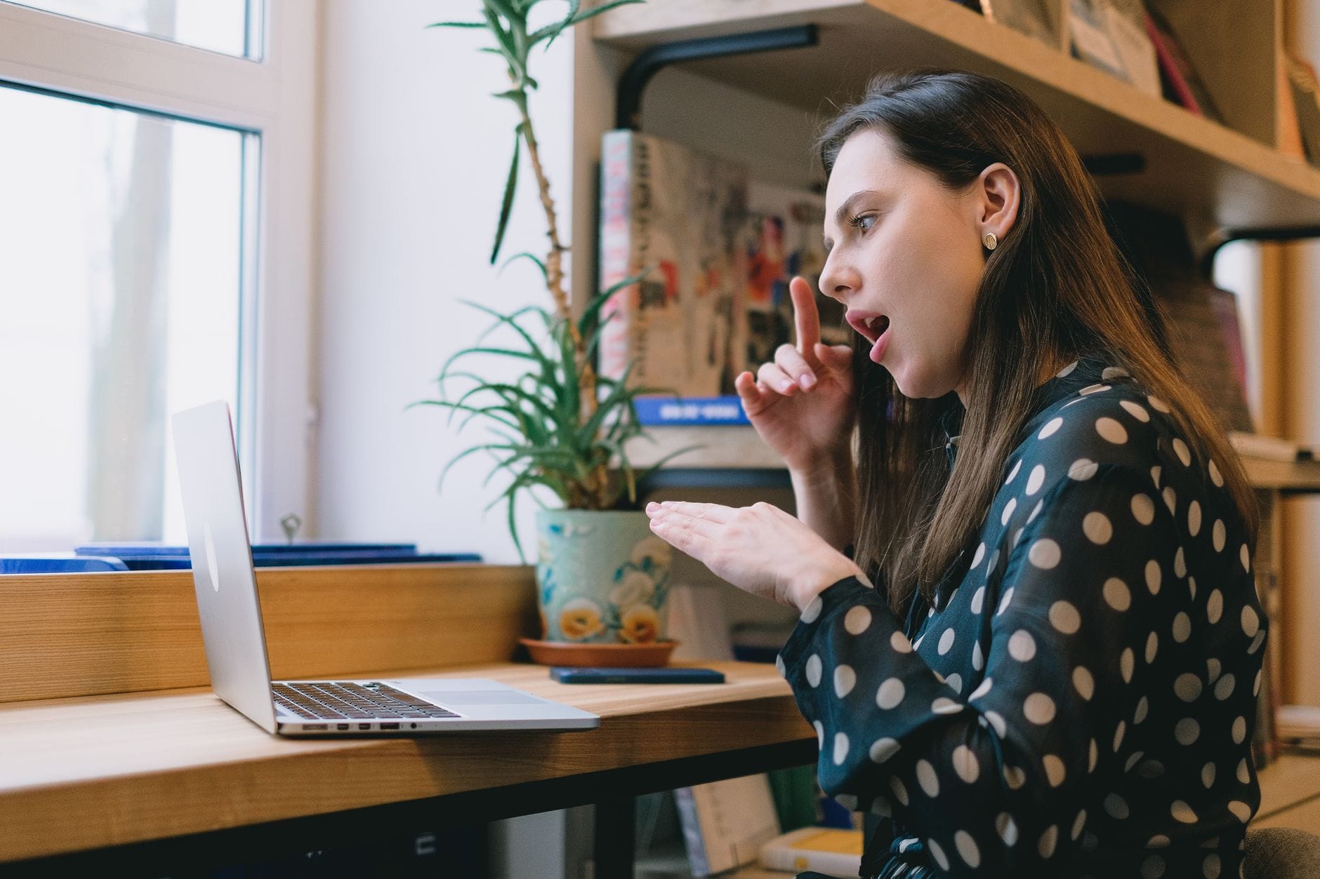 Kobieta przy laptopie uczy się języka migowego podczas lekcji online